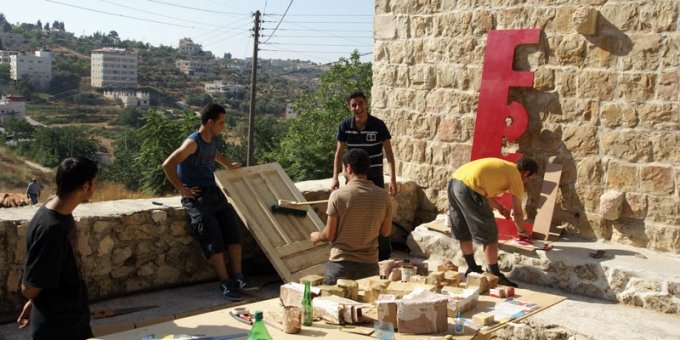 Lokale håndværkere i gang med skilt og opbygning. (Foto: YNKB)