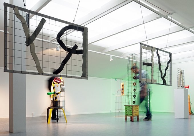 Miguel Vega Olivares i ovenlyssalen i SAK Kunstbygning, set gennem værket <i>Recovery</i>, blandede materialer. Foto: Jerry Jakobsfeld