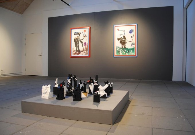 Udstillingsview, <i>Mostly Black and White</i>, Kunstpakhuset 2014. Bjarne W. Troelstrup: <i>Totem</i>, skulpturer, varierende str., 2012-13 og John Kørner: litografier fra serien <i>Gallery Fruits</i>, 2007. Foto: Bente Jensen