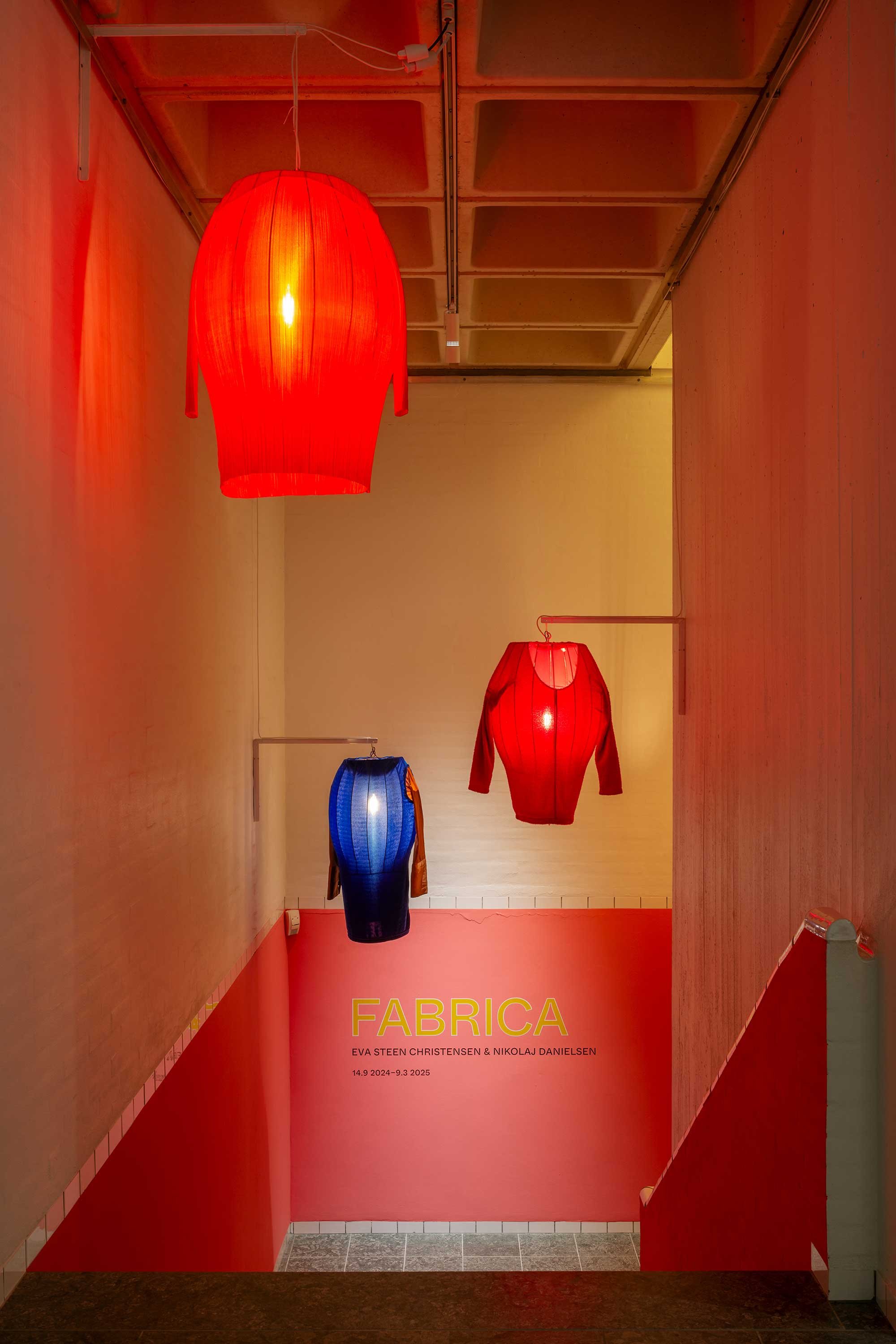 <i>AKT 2 TEKSTILHAVET</i>. I loftet hænger lanterneagtige lamper af jern og beklædningsdele som små sjæle med lysende hjerter, der svæver over tekstilhavet. Foto: Jacob Friis-Holm Nielsen
