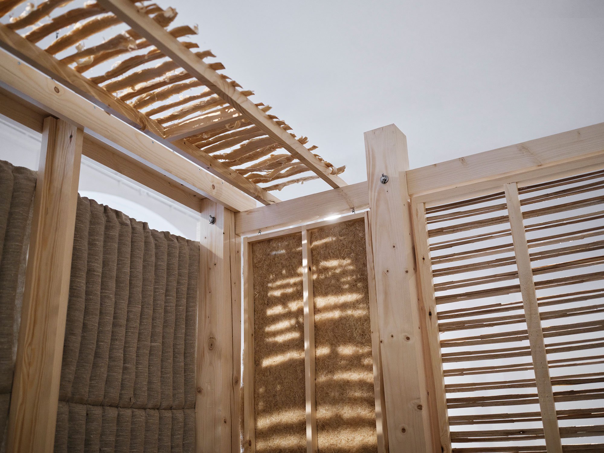 Loft og vægge i Martinsens pavillon. Lofter af spåner fra asketræ. Vægge af hørtekstil, polstret med ålegræs, vægpaneler af hampefibre. Dør af dunhammer af Sara Martinsen. Foto: Kristian Holm
