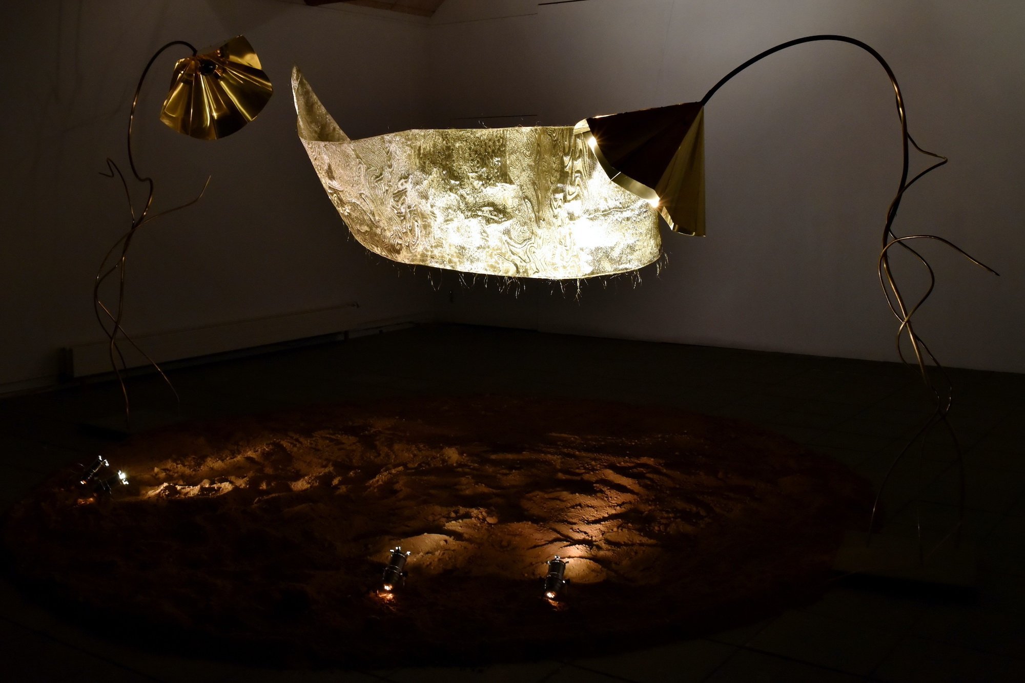 <i>Eternity – Fingers Crossed</i>, højtalerskulpturer af messing, betonflise, tekstil af ståltråd og guldtråd, duft. 2024. Foto: Ole Jørgensen