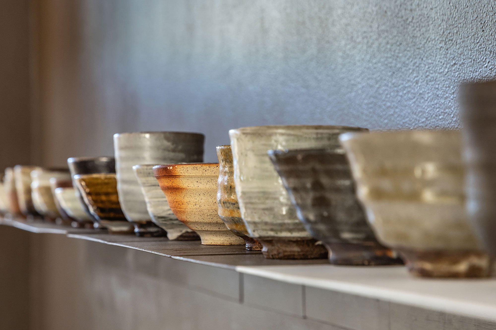 Anne Mette Hjortshøj <i>28 stk. kopper/skåle</i> Lokalt Bornholmsk ler og glasur.
Brandefyret. Udvalgt i perioden 2017 - 2024. Foto: Køppe Contemporary Objects