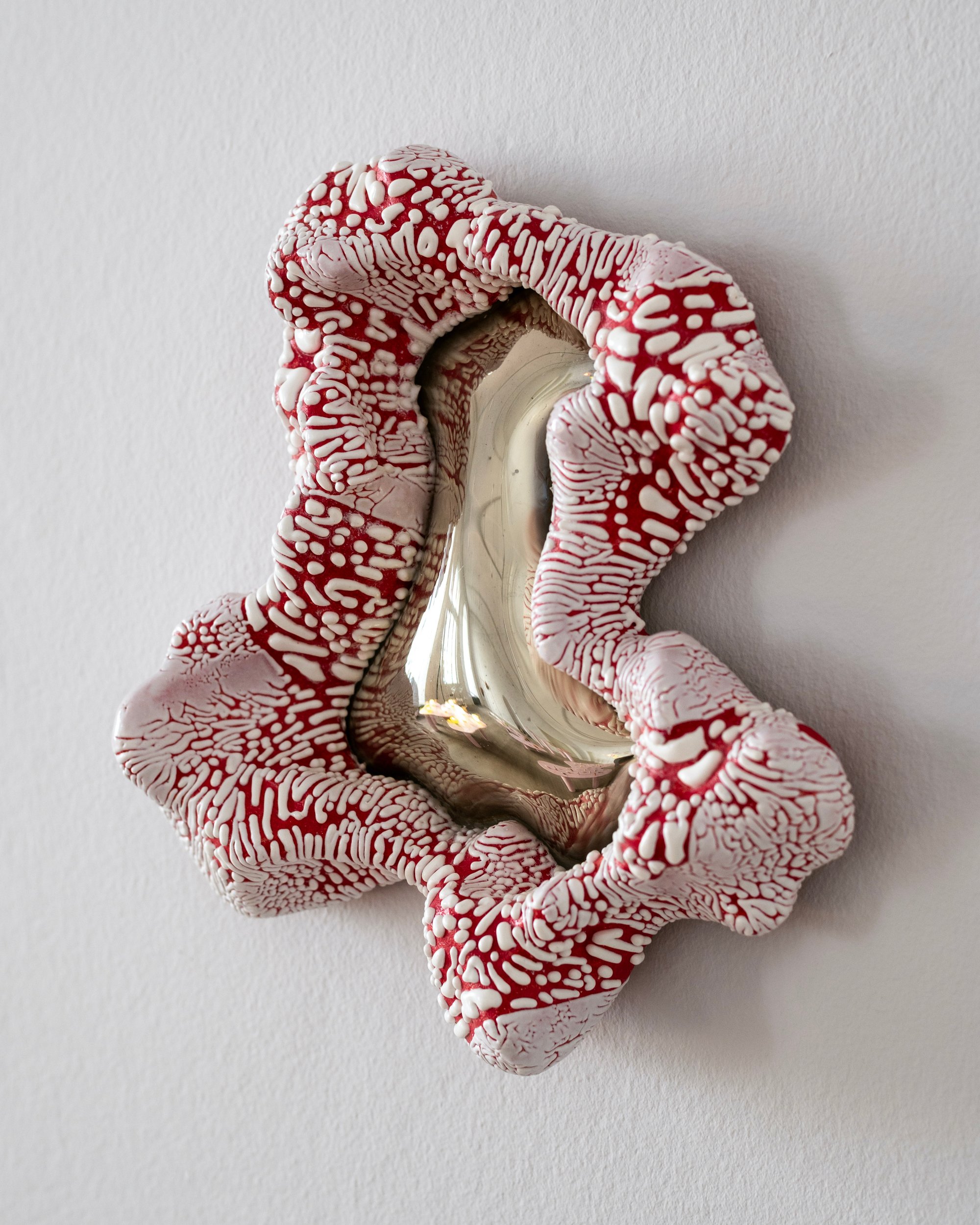 Laura Astrup Larsen, <i>Organisme På Væg. Hvid med rød underglasur</i>, stentøj, glas, 2024. Foto: Malthe Emanuel