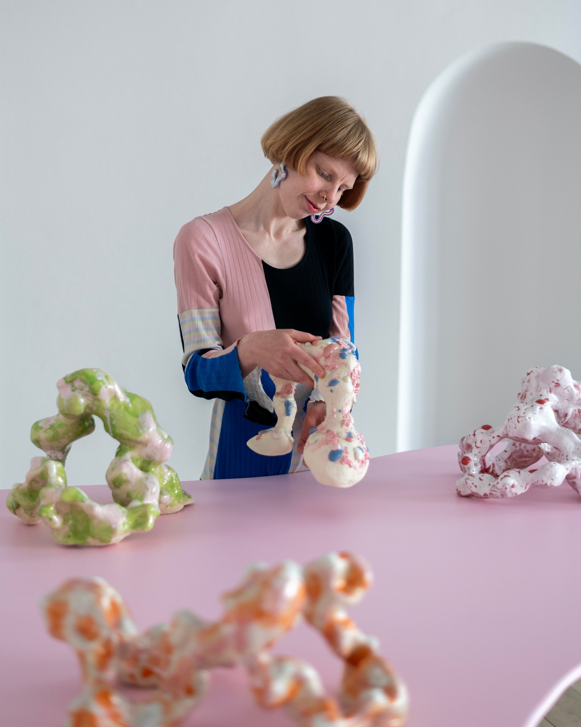 Portræt af kunstneren Laura Astrup Larsen sammen med keramiske organismer. Foto: Malthe Emanuel