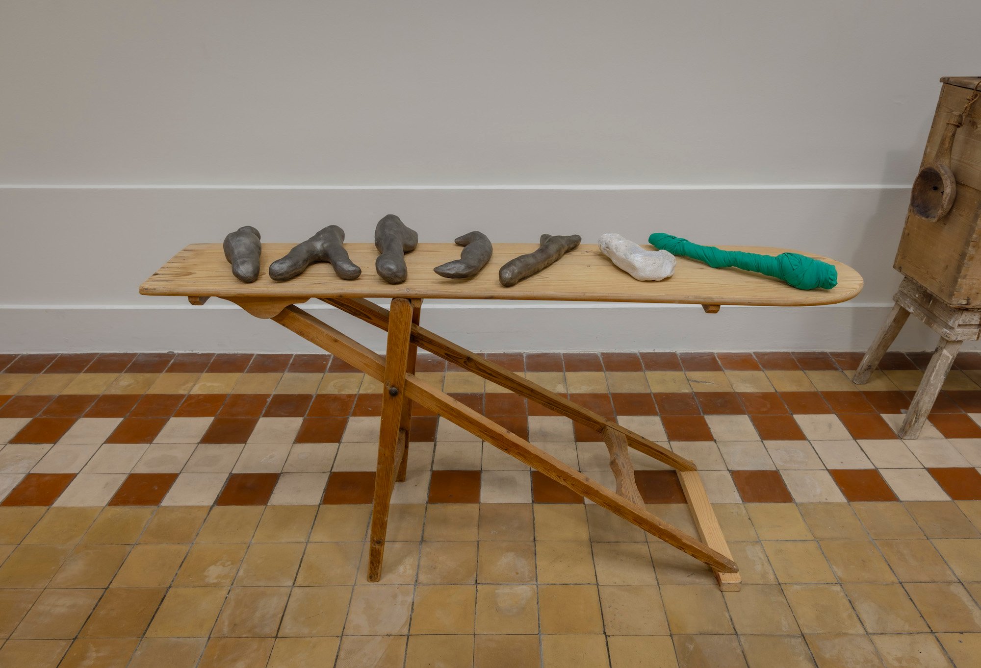 Milena Bonifacini, strygebræt med 5 støbejerns objekter, flintesten og tekstil objekt. 2021-24, Det Fynske Kunstakademi Odense. Foto: Malle Madsen