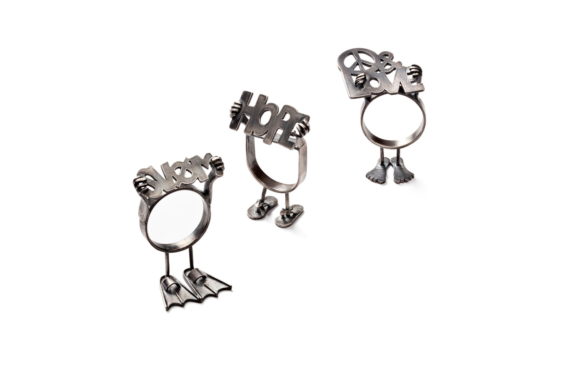 Marie- Louise Kristensen, fingerringe, 2024, <i>SVØM</i>, sølv, 42 x 36 x 16 mm, <i>HOPE</i>, sølv, 40 x 26 x 17 mm, <i>PEACE & LOVE</i>, sølv, 40 x 25 x 26 mm. Foto: Dorte Krogh.