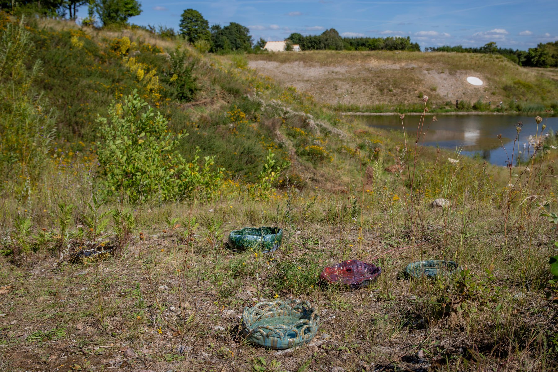 JOHANNE SKOVBO LASGAARD, TÅREKAR, 2025. 5 keramiske drikkekar med fordampet vand fra Suså. En tårekanal løber igennem dit landskab og fylder dit drikkekar. Et offerkar til dyrene i min have. Fasanen sidder på toppen af hasselbusken. Dette kar er til den.