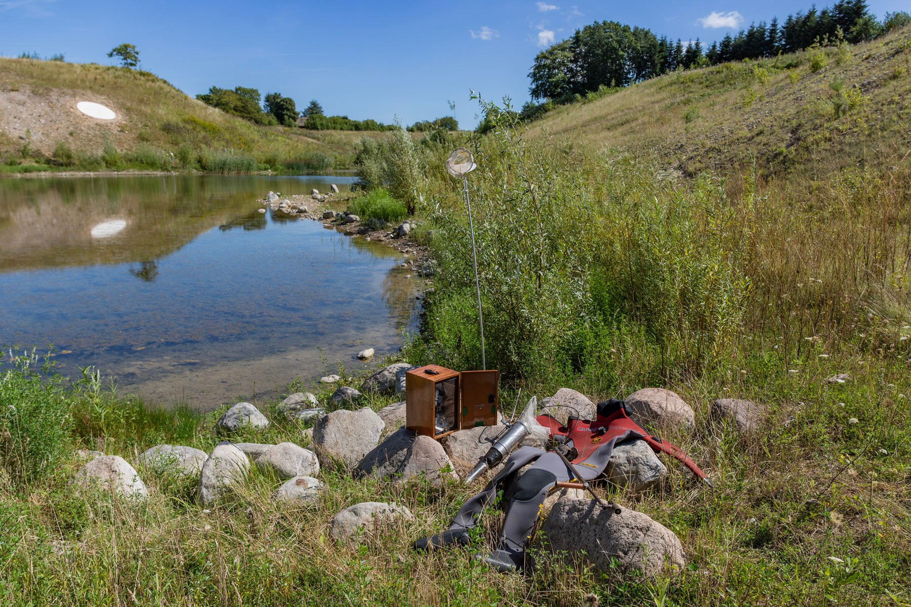 HARTMUT STOCKTER, OPERATION HVEPSESALAMANDER, 2025. Træ, stål, aluminium, oliemaling, net, mikroskop, dykkerdragt, afspærringsmateriale.