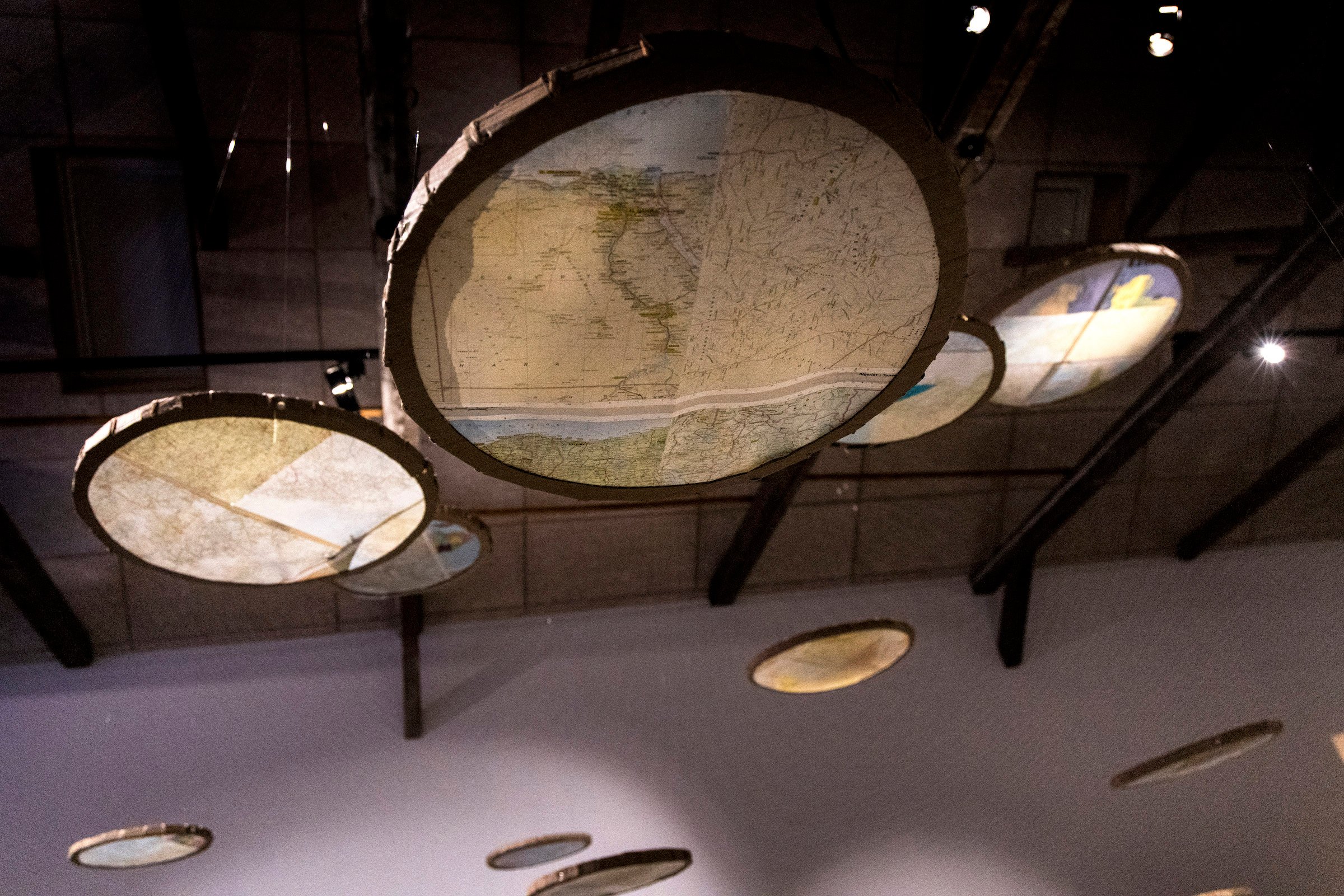 Detalje: Amir Zainorin, Cartologica aka The World in Nyiru, karton/ atlas-sider/ spejle/ farvet akrylfilme/ tråde/ motor, 2025. Foto: Tom Laursen.