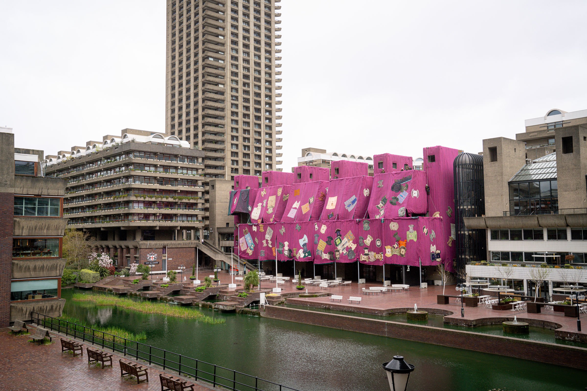 Ibrahim Mahamas <i>Purple Hibiscus</i> under installation på Barbican Centres betonfacade, 2024. Courtesy Ibrahim Mahama, Red Clay Tamale, Barbican Centre, London and White Cube. © Pete Cadman, Barbican Centre.