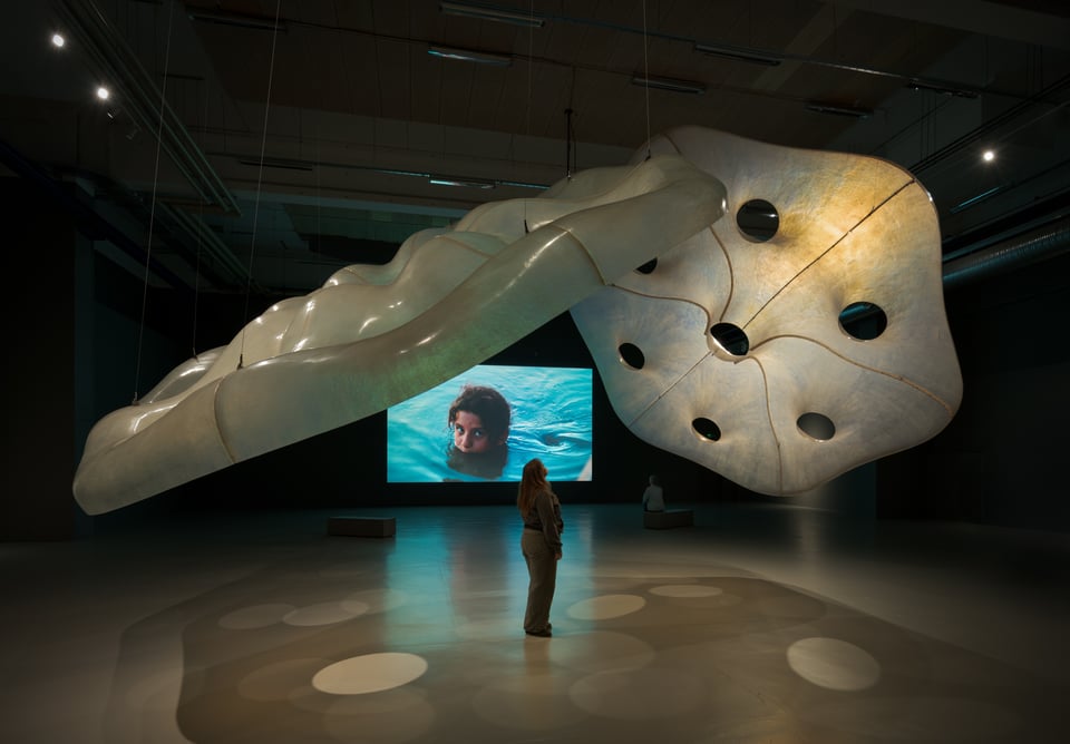 Alia Farid: <i>Amulets</i>. I baggrunden videoværket <em>Chibayish</em>, som dokumenterer livet i Al-Ahwar-området. Installationsbillede fra udstillingen på CC: <i>A Sounding of the Earth</i>. Foto: David Stjernholm.